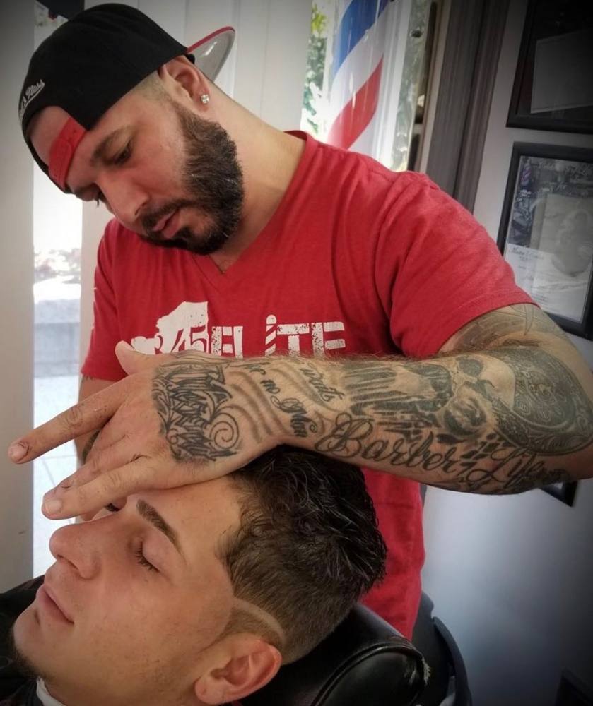 Justin, master barber at Abscission Barbershop, lining up a client's haircut